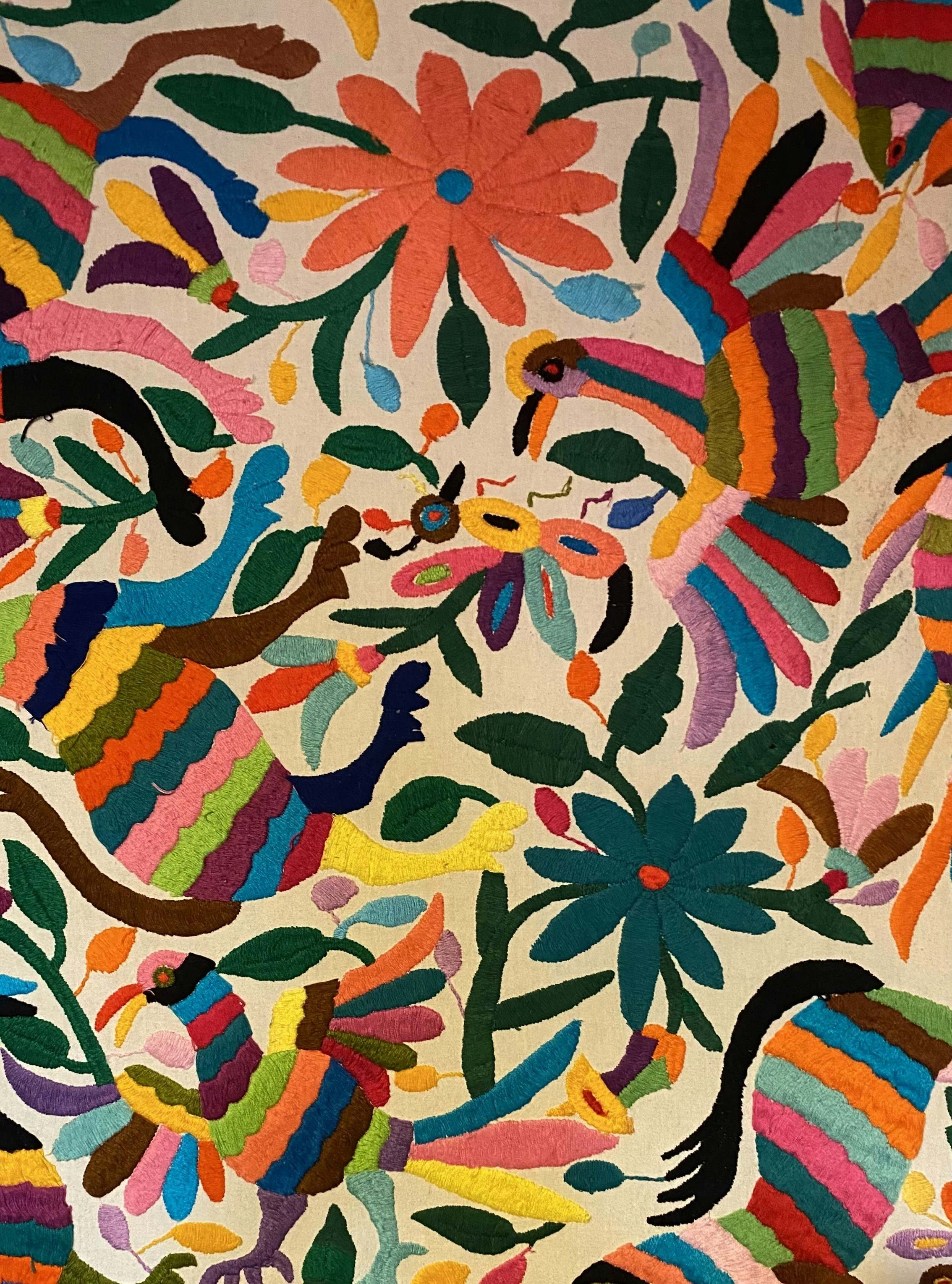 Colorful embroidery featuring birds and flowers with a variety of bright colors. The design includes vibrant hues and intricate details, showcasing a traditional folk art style.